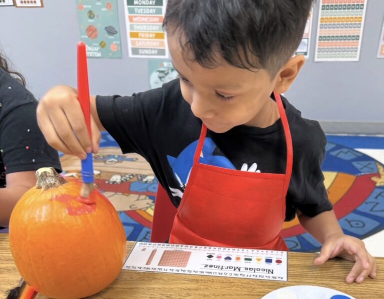 A child painting a pumpkin in the HFA classroom