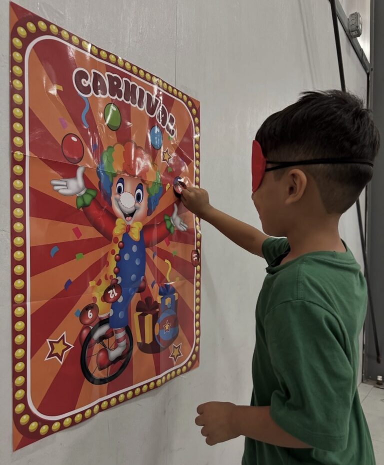 A child taking part in a carnival game with a clown poster
