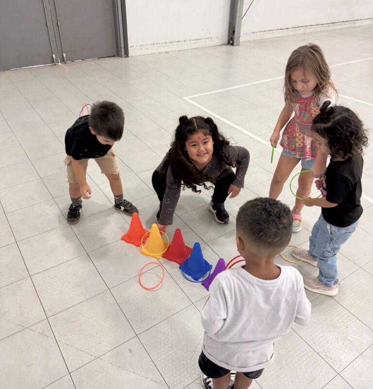 Children playing a ring-toss game together in the indoor gym